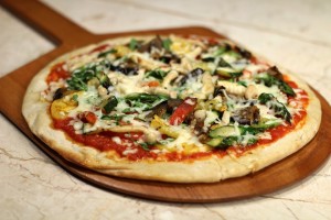 Primavera Pizza made with summer squash, artichokes, red onions, sun-dried tomatoes, zucchini, fresh basil, crumbled feta cheese, nonfat mozzarella cheese, black pepper, olive oil and raw garlic (700 calories). 